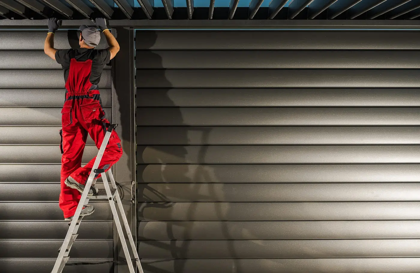 A professional technician repairing a roller shutter with precision tools.